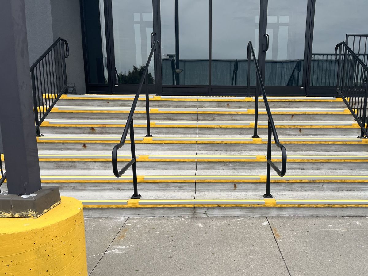 Entrance stairs with complementing yellow anti-slip nosing strips added to each tread